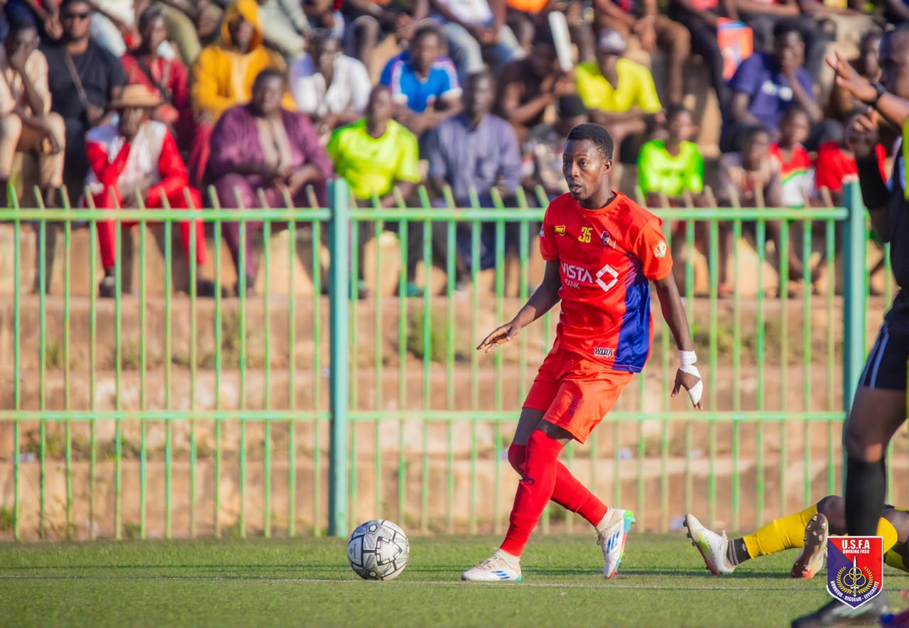 Sanou on the ball during a match, away kit